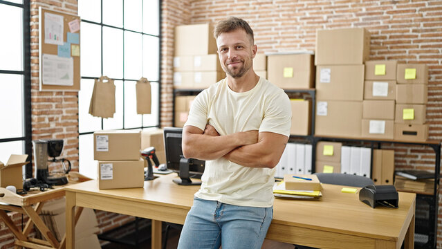 Young man ecommerce business worker standing with arms crossed gesture at office