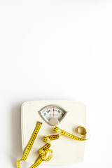 White floor weight scales and tape measure, top view