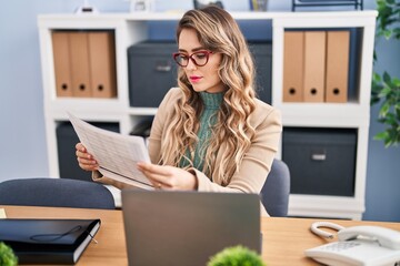 Young woman business worker reading document working at office