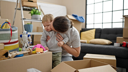 Fototapeta na wymiar Father and son unpacking cardboard box at new home