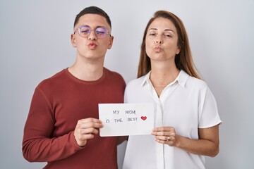 Mother and son holding my mom is the best card looking at the camera blowing a kiss being lovely...