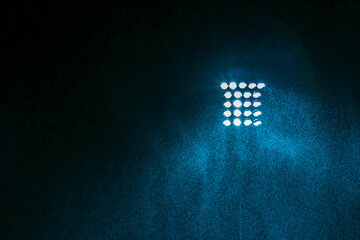 Blue color tone of Spotlight of football or soccer stadium with rain water at night time.