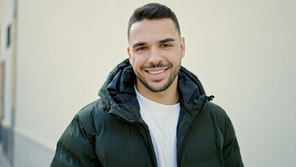 Young hispanic man smiling confident standing at street