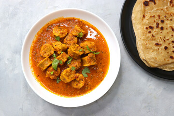 Rajasthani Gatta Curry or Besan Ke Gatte Ki Sabzi. Gatte are gram flour roundels or chickpea flour dumplings are cooked in a spicy, tangy yogurt based curry. delicacy of Rajasthan, India. copy space.