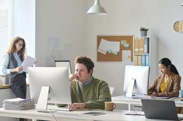 Group of colleagues working at their workplaces in modern office