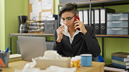 Young beautiful hispanic woman business worker talking on smartphone being sick at office