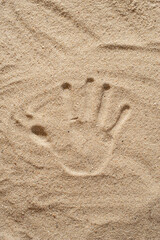 The texture of the sand about the footprints of hands and feet