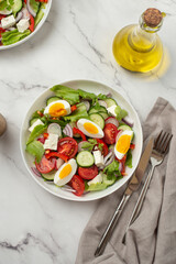 salad of fresh vegetables and greens with egg and feta cheese