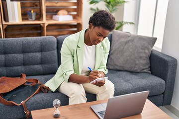 African american woman psychologist having teleconsultation sitting on sofa at psychology center