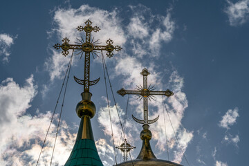 Gilded Orthodox crosses on the domes of the temple against the sky
