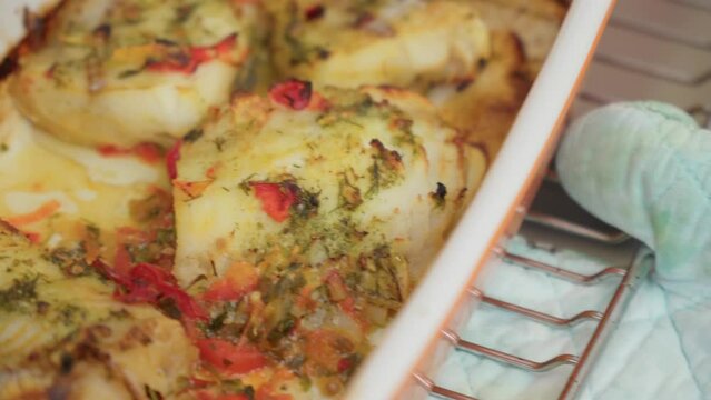 Baked cod fish in the oven. Cooking fish with peppers and herbs in the oven. Selective focus.