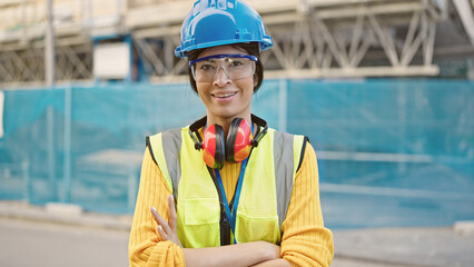 Young beautiful hispanic woman architect smiling confident standing with arms crossed gesture at street