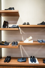 Shelf with men's stylish shoes in the store