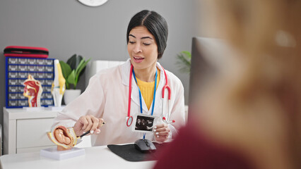Fototapeta premium Young beautiful hispanic woman gynecologist having gynecology consultation with patient at clinic