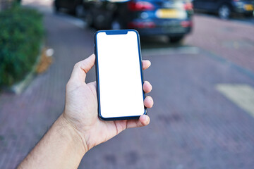 Man holding smartphone showing white blank screen at street