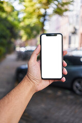 Man holding smartphone showing white blank screen at street