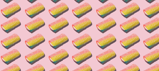Pattern of colored candies on a pink background
