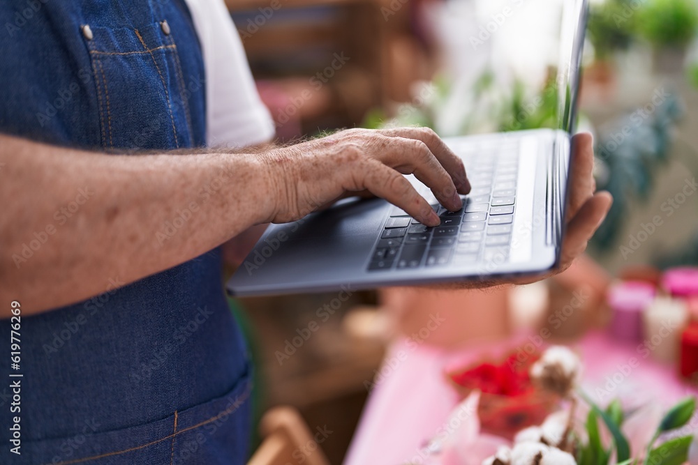 Canvas Prints Middle age grey-haired man florist using laptop at florist