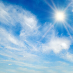 Naklejka na ściany i meble The bright sun, blue sky and light clouds.