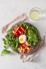 quinoa with poached egg, avocado tomato salad leaves. healthy vegetarian lunch breakfast