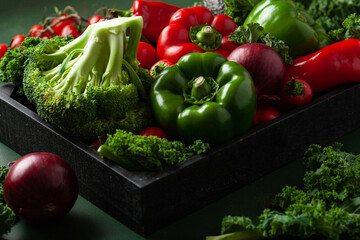 assorted red and green vegetables tomatoes, bell peppers, kale avocado