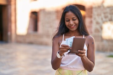 Young beautiful woman smiling confident counting dollars at street