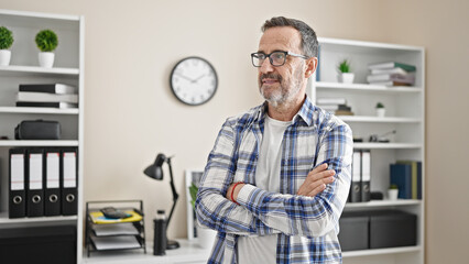 Middle age man business worker standing with arms crossed gesture and serious expression at office