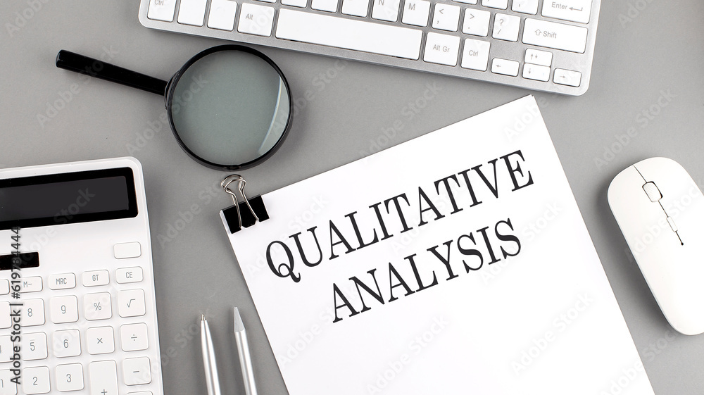 Poster qualitative analysis written on paper with office tools and keyboard on the grey background