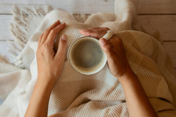 taza de café con espuma en manos de una mujer, vista cenital