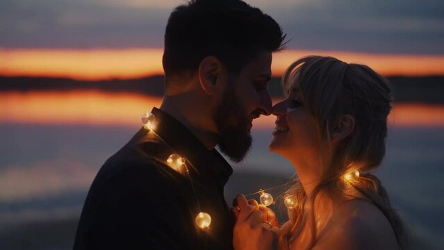 Handsome Bearded Man Putting Garland On His Beloved Woman In Romantic Date On Shore, Tender Kiss