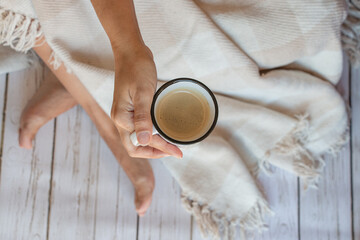 taza de café con espuma en manos de una mujer, vista cenital