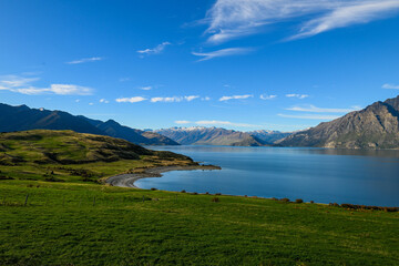 A view of mountains behind Lake Pukaki in Glentanner, Canterbury, New Zealand on a sunny afternoon. 