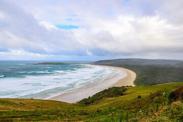 A view of the coast of the sea over farm land in New Zealand