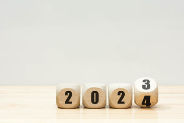 Wooden 2023 to 2024 new year white background. 
Word 2023 - 2024 wood cube on wooden desk for copy...