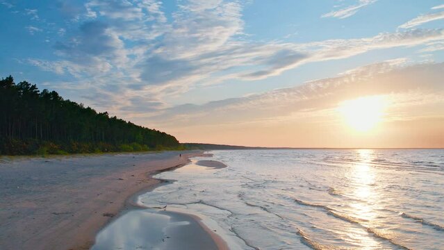 Discover the magical world of Jurmala's beach through the lens of a drone, capturing the dynamic sea waves and the glimmering golden sand