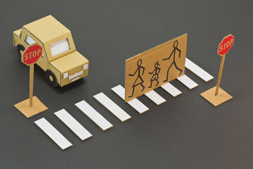 Black and white pedestrian crossing with cardboard stopped car a
