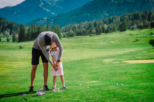 Golf Lessons. Golf instructor giving game lesson to a young girl