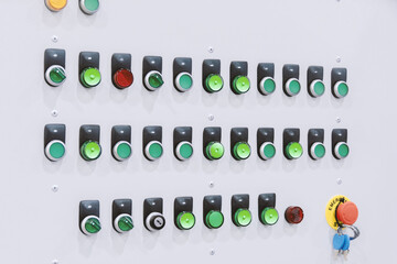Round buttons of the industrial control panel on the shield in green and red.