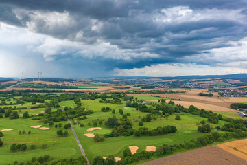 Fototapeta na wymiar Bird's-eye view of a golf course in Taunus/Germany just before a thunderstorm