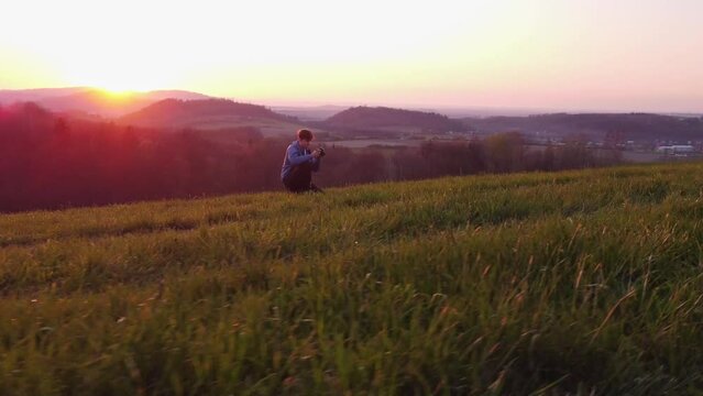 Amateur photographer sets up and shoots his models during the golden hour in a natural magical scenery. 4k video
