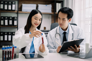 Fototapeta premium Medical team students discussing over blood sample in the room.