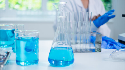 Glassware, beaker or test tube with blue substance or liquid. Concept of laboratory  background. Scientific analysis tools background. Chemistry and experiment glassware.