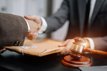 Lawyer shaking hands with client after discussing final contract agreement.