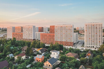 Fototapeta na wymiar urban modern landscape: multi-colored new buildings residential buildings, private low-rise buildings, gardens on a warm summer evening