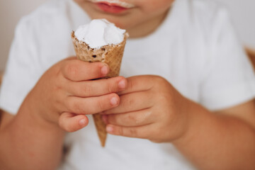 little hands holding a waffle cone with ice cream