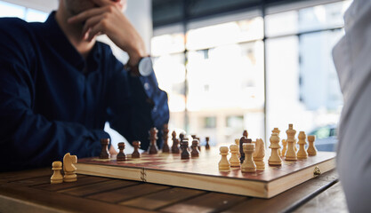 Board game, chess and men playing at a table in office while thinking of strategy or plan. Male...