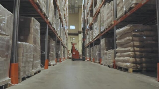 Large modern warehouse in the factory. A forklift is driving through a large warehouse. Moving through a modern warehouse.