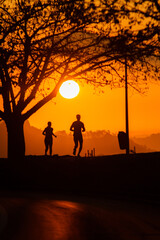 silhouettes of people running during dawn in Rio de Janeiro.