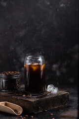 Cold coffee in a glass on a dark background