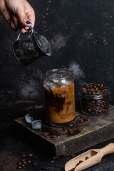 Cold coffee in a glass on a dark background